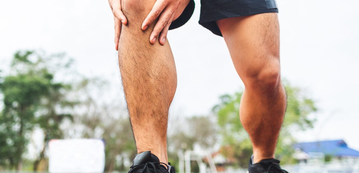 man runner holds knee in pain