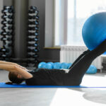 Woman doing core strengthening exercises using exercise ball