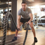 Man doing Battle Rope waves exercise at a gym