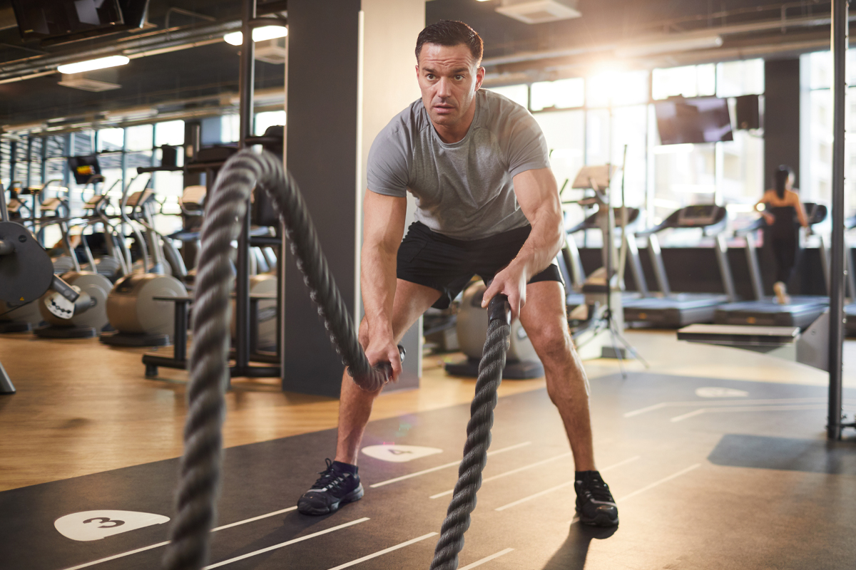 Man doing Battle Rope waves exercise at a gym