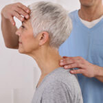 Senior women receiving neck and back physical therapy by male physical therapist