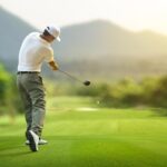 Man doing a proper golf swing in the golf course.