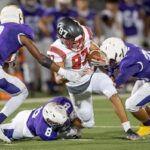 A group of high school football players making an intersection play during a football game