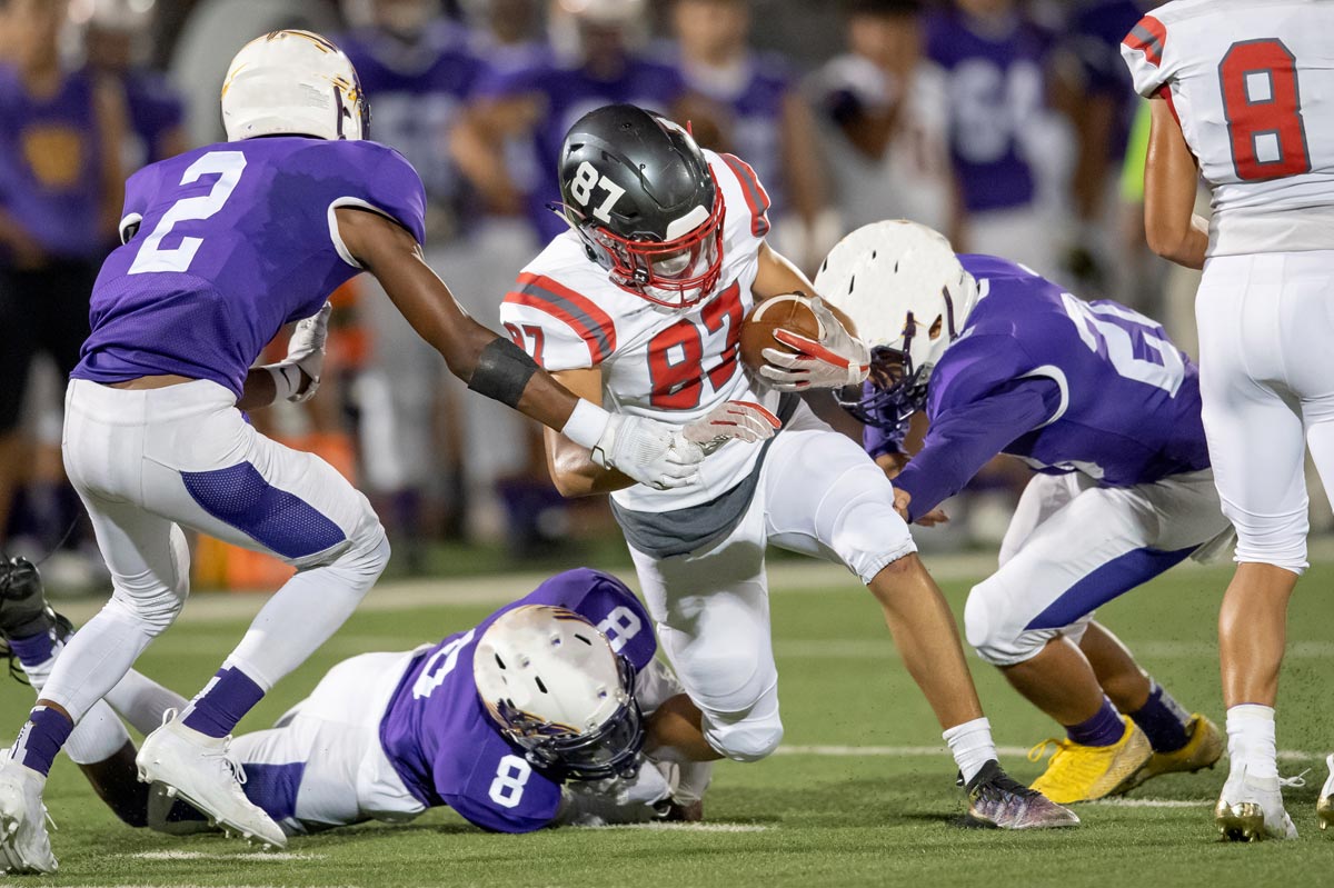 A group of high school football players making an intersection play during a football game
