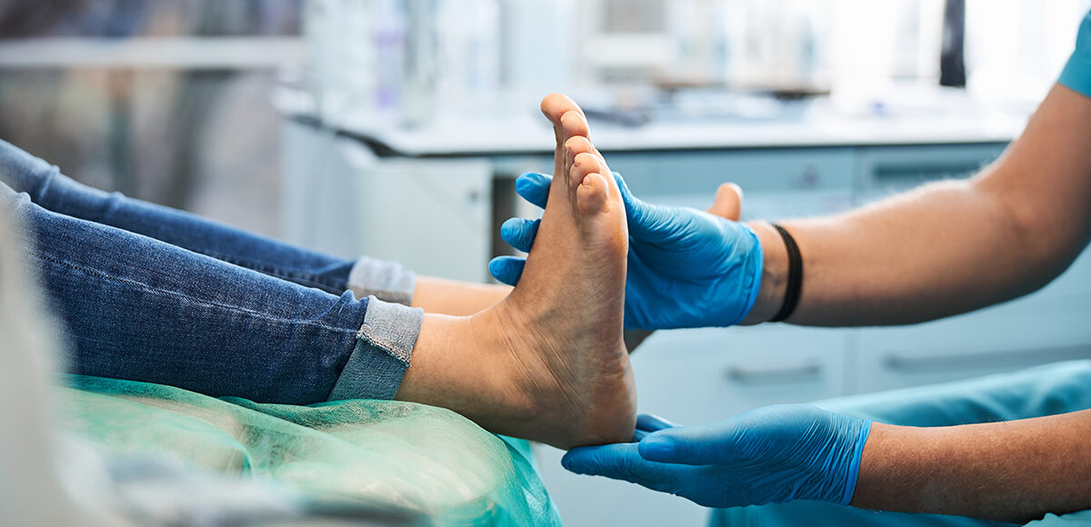 Close up side view portrait of female feet on the medical chair while professional chiropodist examining its in beauty clinic