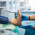Close up side view portrait of female feet on the medical chair while professional chiropodist examining its in beauty clinic