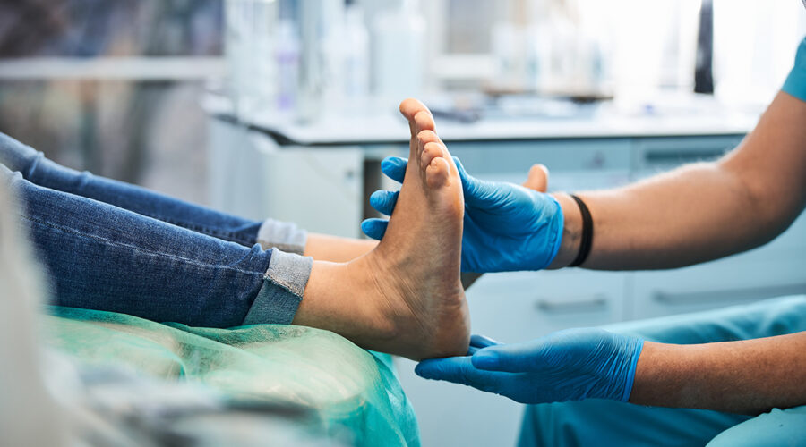 Close up side view portrait of female feet on the medical chair while professional chiropodist examining its in beauty clinic