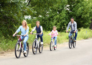 Family riding their bikes around a park