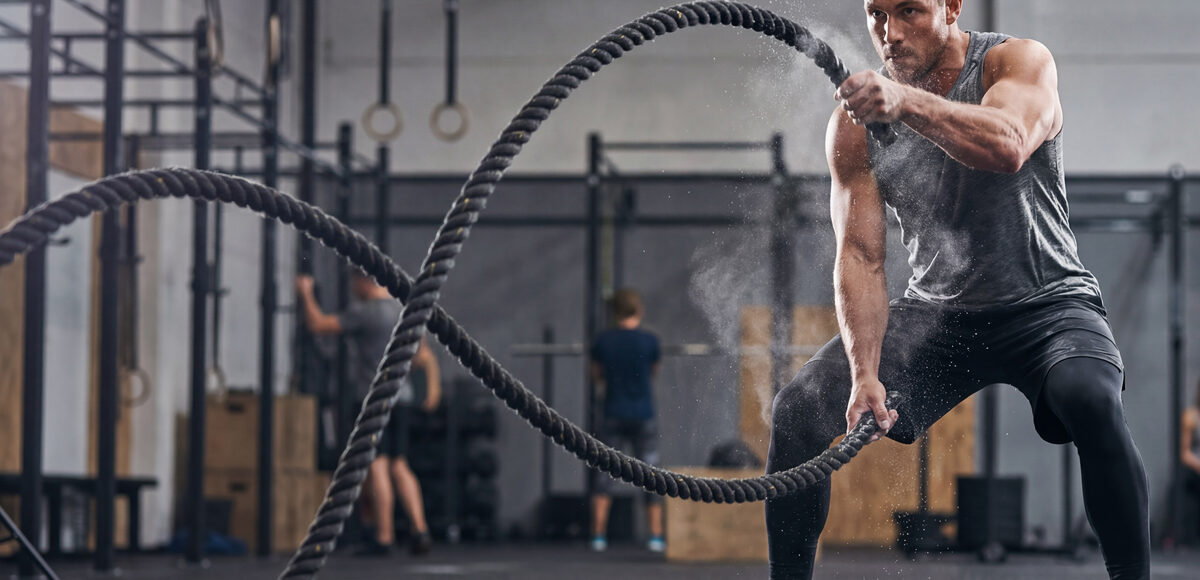 man doing battle rope exercises