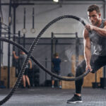 man doing battle rope exercises