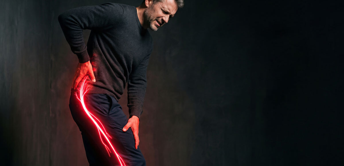 Middle-aged man holding his lower back and hip in pain, with a red and yellow electric spark extending from his hip down his leg to represent nerve pain.