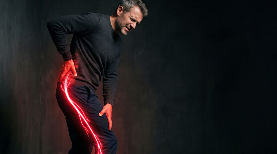 Middle-aged man holding his lower back and hip in pain, with a red and yellow electric spark extending from his hip down his leg to represent nerve pain.